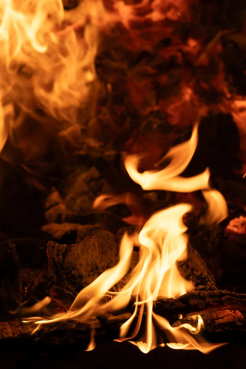 Nahaufnahme züngelnder Flammen und glühender Glut in einem Feuer